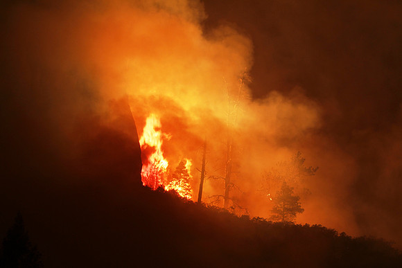 Fire reflects off of the larger cliffs behind it at the mouth of West Fork